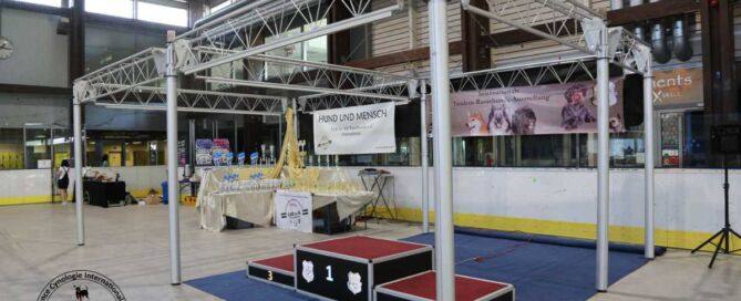 Pokaltisch unter ACI mobiler Messestruktur mit Aluminium-Traversen und Podium für Platz 1 bis 3